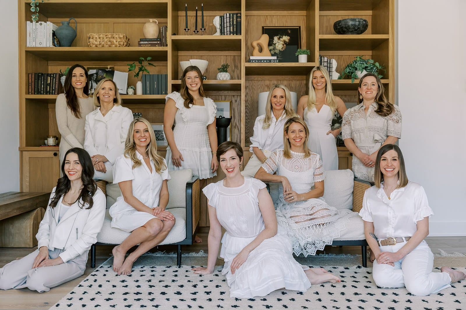 Team group photo seated in an oak-shelved lounge
