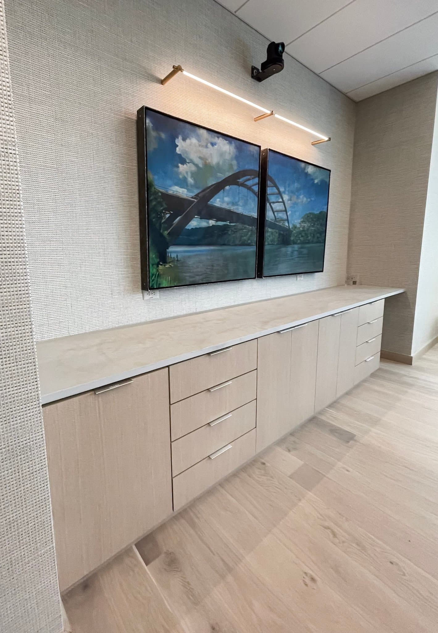 Office media wall with dual displays and a long credenza