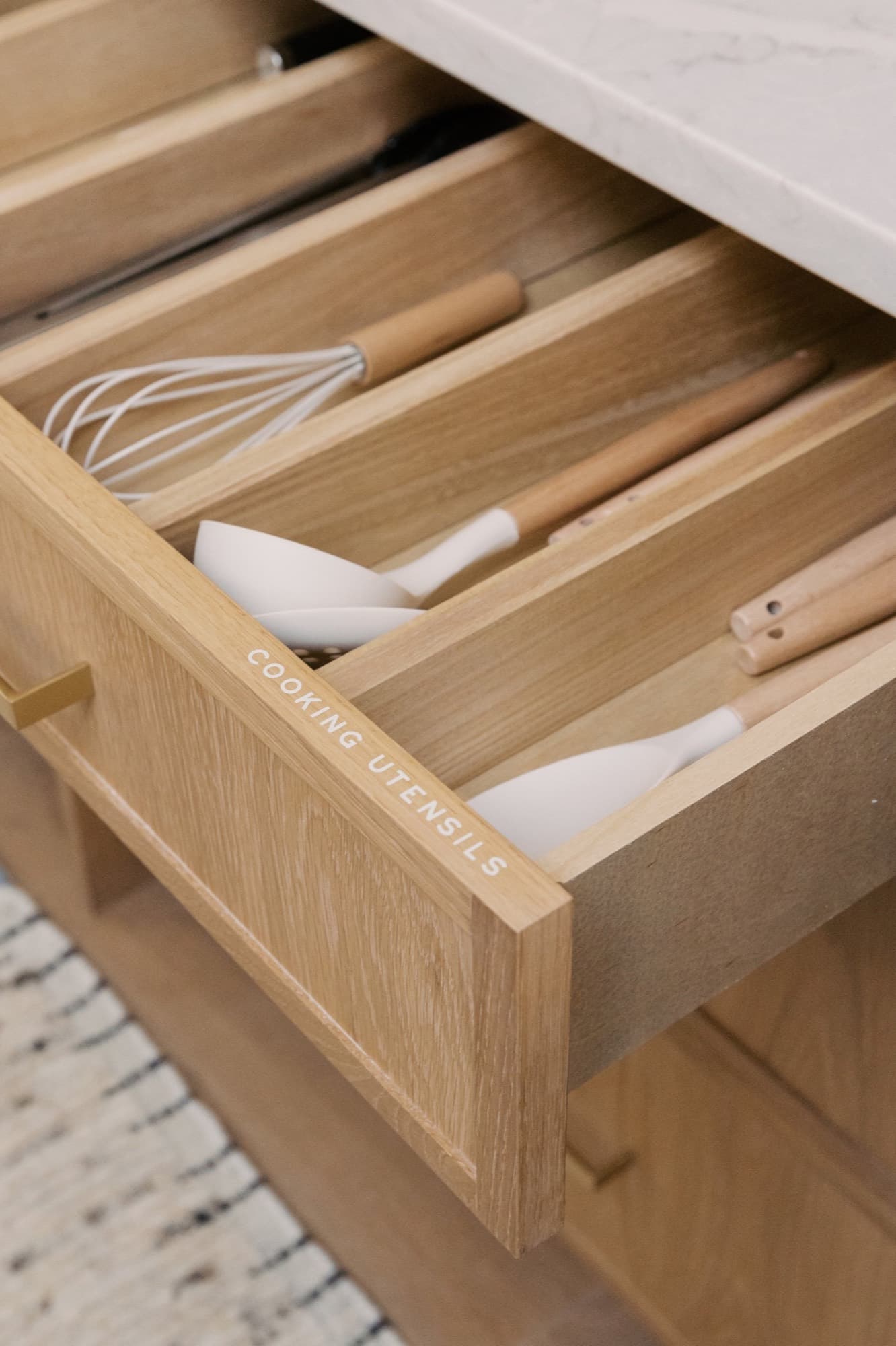 White oak drawer with built-in dividers for cooking utensils