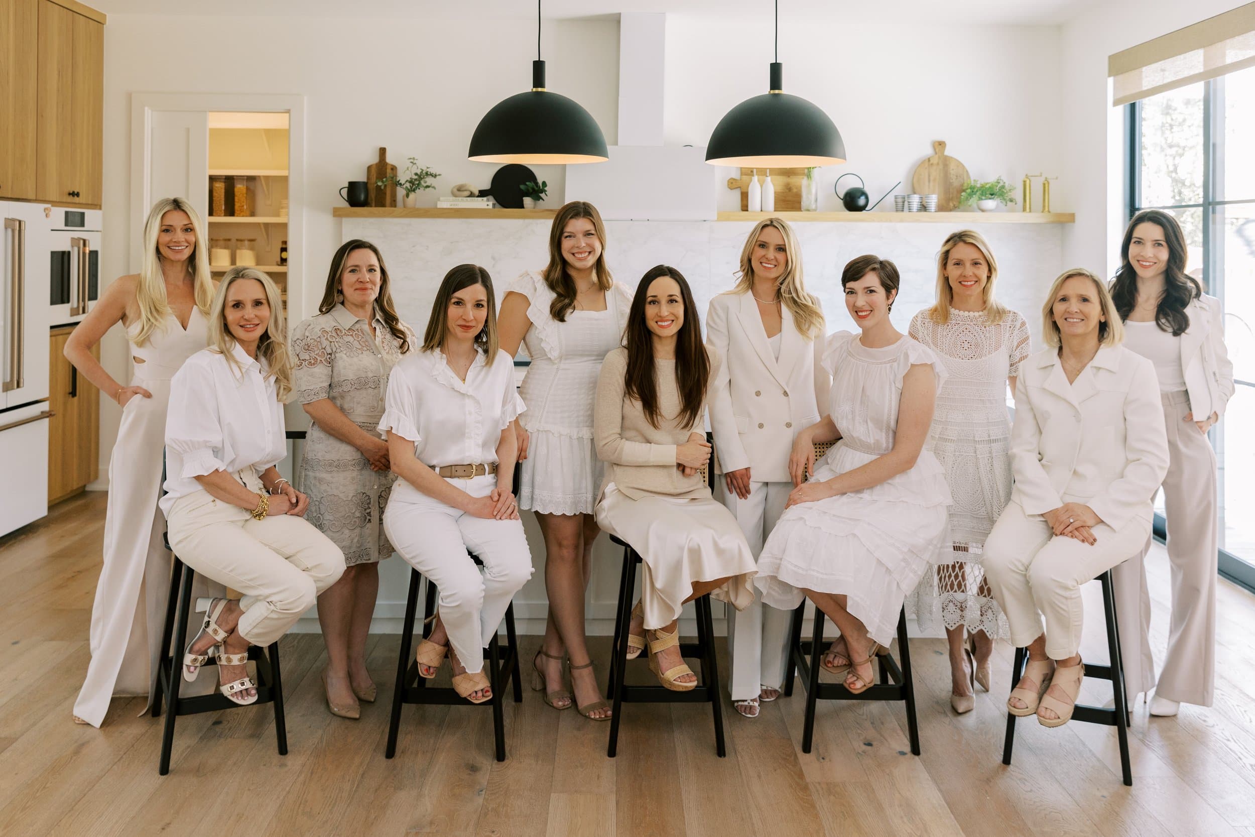 Team portrait on black stools in a white kitchen