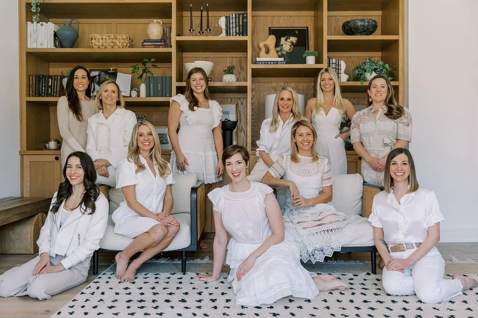 The B. Moore Organized team, dressed in white, seated together in an oak-shelved library