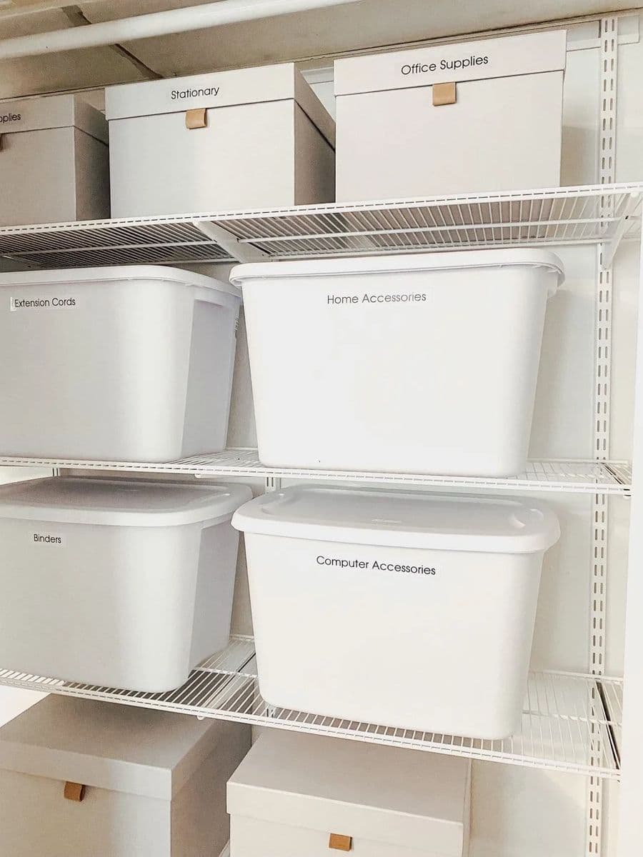 Labeled white storage bins on garage shelving