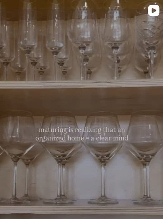Rows of wine and martini glasses on an organized bar shelf, captioned: maturing is realizing that an organized home = a clear mind