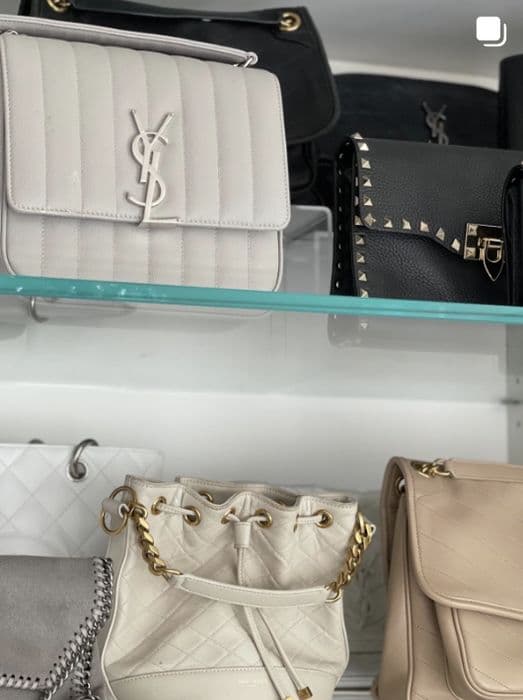 Designer handbags displayed on lit glass shelves