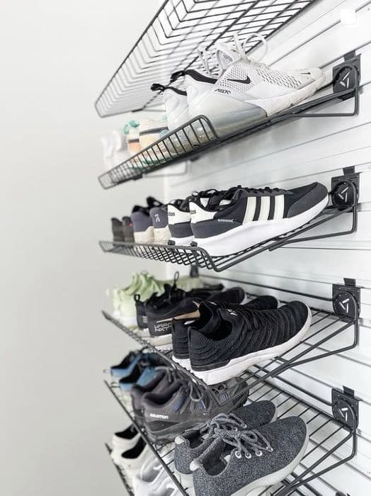 Wall-mounted racks holding an organized sneaker collection