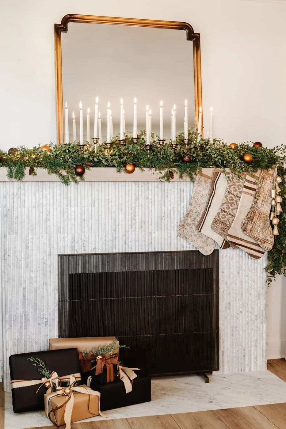 Candlelit mantel with garland, stockings and wrapped gifts