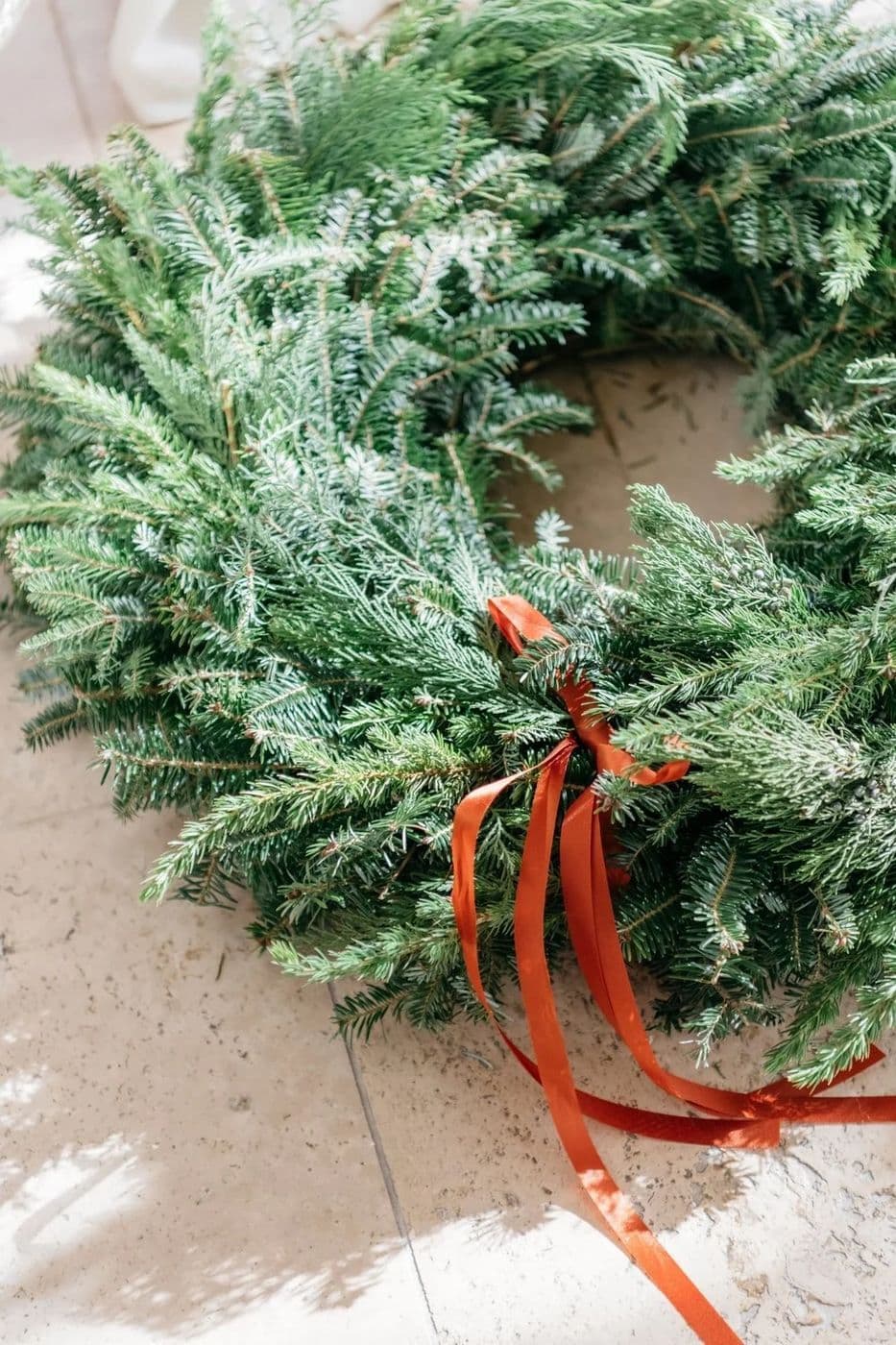Evergreen wreath tied with a rust velvet ribbon